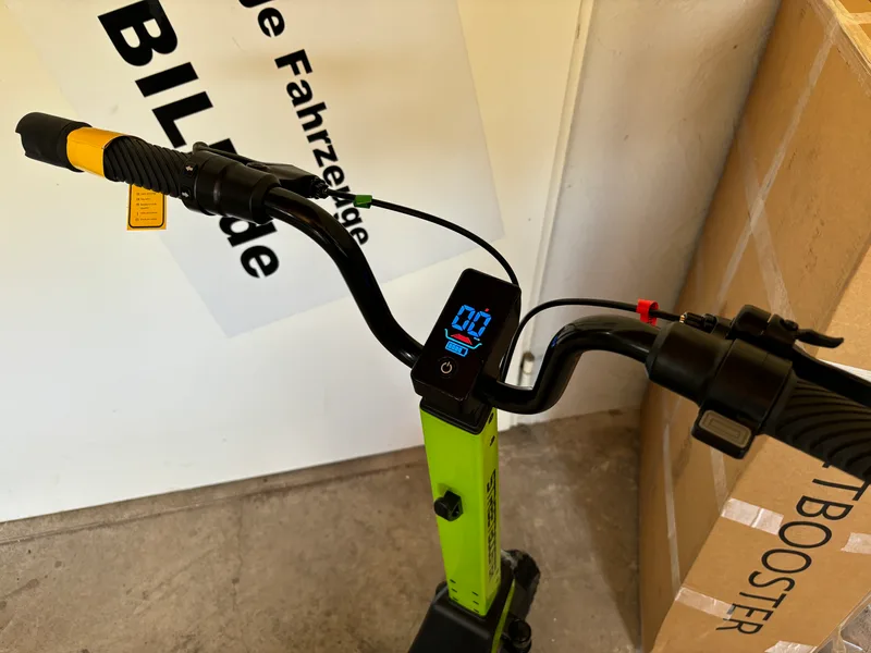 Streetbooster Pollux E-Scooter grün, Seitenansicht auf Holzboden